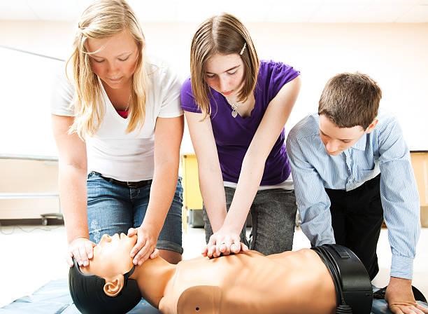 performing CPR on a doll for training