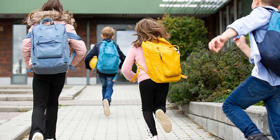 children running with their backpacks